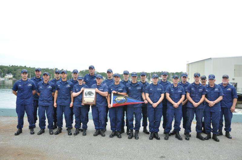 THE COAST Guard Station was recently awarded with the Sumner I. Kimball Award, which is given to the station that keeps exemplary care of boat material equipment, boat and personal protective equipment, has superlative crew proficiency and compliance with training requirements and readiness. Here, the crew stands near the harbor with the plaque and pennant they received. BEN BULKELEY/Boothbay Register